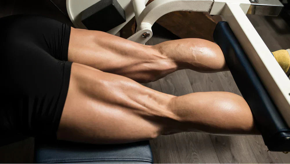 Homme musclé en train de faire du leg curl allongé